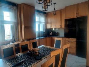 a kitchen with wooden cabinets and a table with chairs at Apartament na Libelta in Wągrowiec