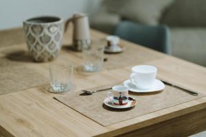 a wooden table with two cups and plates on it at Aura Residence in San Biagio +5 photos