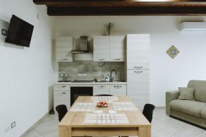 a living room with a table and a kitchen at Aura Residence in San Biagio