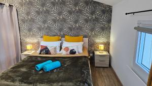 a bedroom with a bed with two blue pillows at GITE familiale avec piscine in Saint-Martin-de-la-Coudre