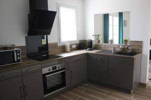 a kitchen with a sink and a microwave at GITE familiale avec piscine in Saint-Martin-de-la-Coudre