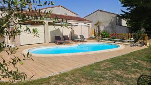 a swimming pool in front of a house at GITE familiale avec piscine in Saint-Martin-de-la-Coudre +6 photos