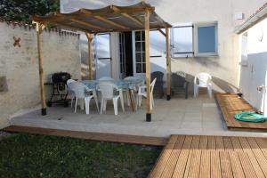 a patio with a table and chairs under a pavilion at GITE familiale avec piscine in Saint-Martin-de-la-Coudre