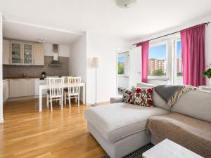 ein Wohnzimmer mit Sofa und eine Küche in der Unterkunft Room in Apartment with Shared Bathroom and Kitchen in Stockholm