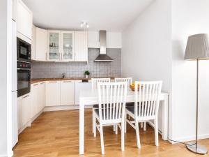 eine Küche mit weißen Schränken und einem weißen Tisch mit Stühlen in der Unterkunft Room in Apartment with Shared Bathroom and Kitchen in Stockholm