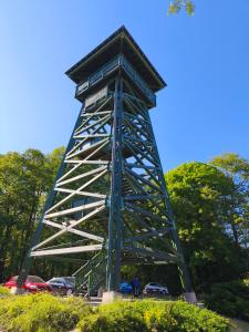 a metal tower with cars parked in a parking lot at Liget Fruit Garden Family Apartman in Zalakaros +9 photos
