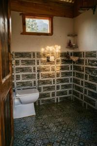 a bathroom with a toilet and a window in it at Hima 360, A Frame Cabin, Panaromic Sainj Valley Views, Bhatkanda in Sainj