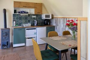 a kitchen with a table and a kitchen with a stove at Szőlőskert Vendégház in Baj