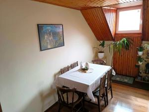 a dining room with a white table and chairs at Liget Fruit Garden Family Apartman in Zalakaros