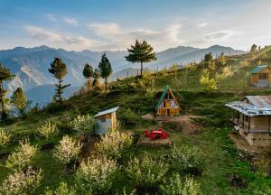 a small house on a hill with mountains in the background at Hima 360, A Frame Cabin, Panaromic Sainj Valley Views, Bhatkanda in Sainj