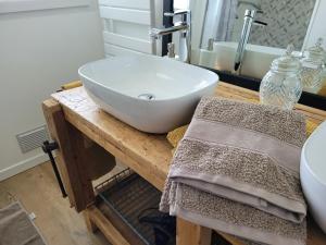 a bathroom with a white sink on a wooden counter at chambres d'hôtes BARTAV aile in Espeluche