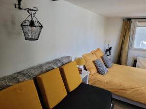 a living room with a couch and a bed at chambres d'hôtes BARTAV aile in Espeluche