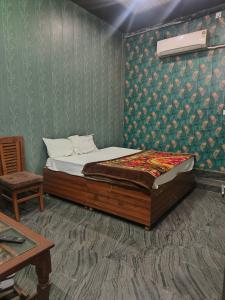 a bedroom with a bed and a chair in it at Rao sahab hotel and restaurant in Etah