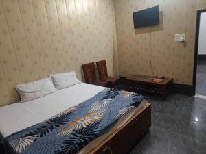 a bedroom with a bed and a tv on the wall at Rao sahab hotel and restaurant in Etah