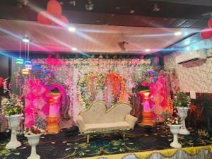 a room with a stage with a couch and flowers at Rao sahab hotel and restaurant in Etah