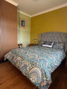 a bedroom with a bed with a colorful bedspread at Hannah's Cottage in Farranfore