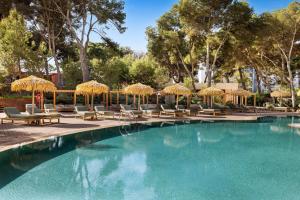 a swimming pool with chairs and umbrellas at Aubamar Palma Resort in Playa de Palma