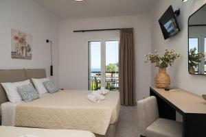 a bedroom with a bed and a couch and a window at Bratis Apartments in Keri