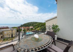 a table on a balcony with a view of the ocean at Apartment Tomic Makarska in Makarska