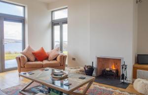 a living room with a couch and a fireplace at Cnoc Na Lobhta in Husabost