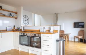 a kitchen with white cabinets and a wooden counter top at Cnoc Na Lobhta in Husabost