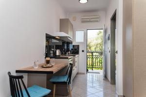 a kitchen with a counter and a table with chairs at Bratis Apartments in Keri