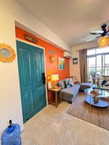 a living room with a green door and a couch at Casa Lio, Caribbean Pool Residence in Boca Chica