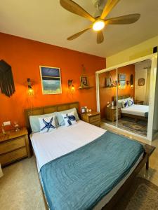 a bedroom with a large bed with orange walls at Casa Lio, Caribbean Pool Residence in Boca Chica +38 photos