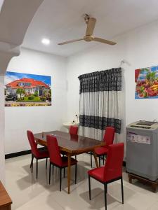 a dining room with a table and red chairs at Elite moon hotel in Kallady