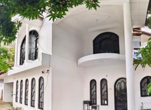 a white building with black doors and windows at Elite moon hotel in Kallady
