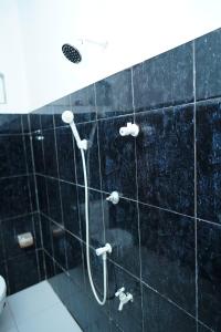 a black tiled bathroom with a shower and a toilet at Elite moon hotel in Kallady +26 photos