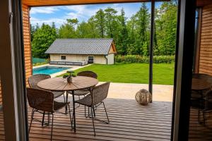 a patio with a table and chairs and a pool at Apartment Relax - Stubenbergsee in Stubenberg