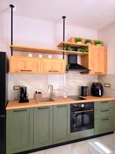 a kitchen with green cabinets and a sink at Anthouli Homes 2, steps from beach and centre in Kardamaina +20 photos