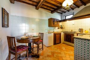a kitchen with a table and a refrigerator at La finestra sul Chianti in Radda in Chianti