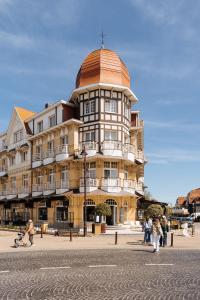 a large building with a dome on top of it at Grand Hotel Belle Vue in De Haan