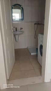 a bathroom with a sink and a washing machine at Katalea Apartment in Shëngjin