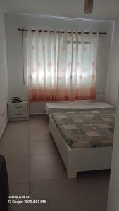 a bedroom with a bed with a curtain and a window at Katalea Apartment in Shëngjin