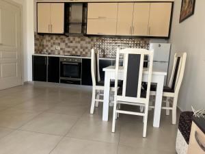 a kitchen with a white table and chairs in it at Katalea Apartment in Shëngjin