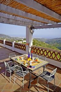 a table and chairs on a patio with a view at Villa El Regalo in Frigiliana
