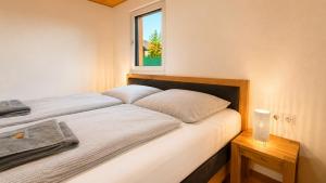 a bedroom with a large bed with a window at Apartment Relax - Stubenbergsee in Stubenberg +26 photos