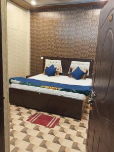a bed in a room with blue pillows on it at Hotel Shree Sanwaliya INN in Ayodhya