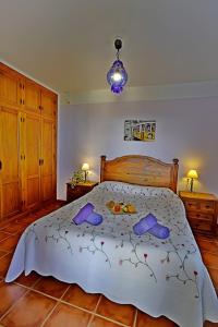 a bedroom with a large bed with slippers on it at Villa El Regalo in Frigiliana +29 photos