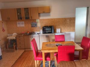 a kitchen with a wooden table and red chairs at Apartment Boka in SJJ +8 photos