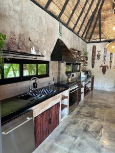 a kitchen with a sink and a stove at Aldea Pukna Tulum in Akumal