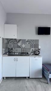 a kitchen with white cabinets in a room at Doma by Kristina in Chrysi Ammoudia