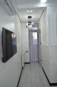 a hallway with a urinal and a television on a wall at PushkinApart in Batumi