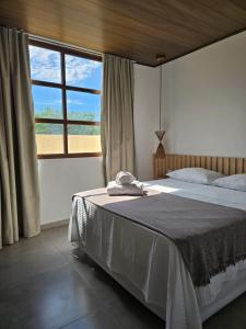 a bedroom with a bed and a large window at Portal do Kite in Barra Grande +41 photos