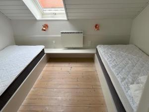 a bedroom with two beds and a mirror in it at Panoramaudsigt og swimmingpool midt i Ebeltoft in Ebeltoft
