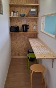 a small kitchen with a table and two stools at LA Jacarandière in Le Cambout