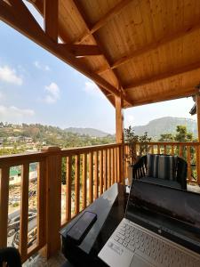 a laptop computer sitting on a table on a deck at The Walnut Homes- Luxury Pine Cottages in Bhīm Tāl